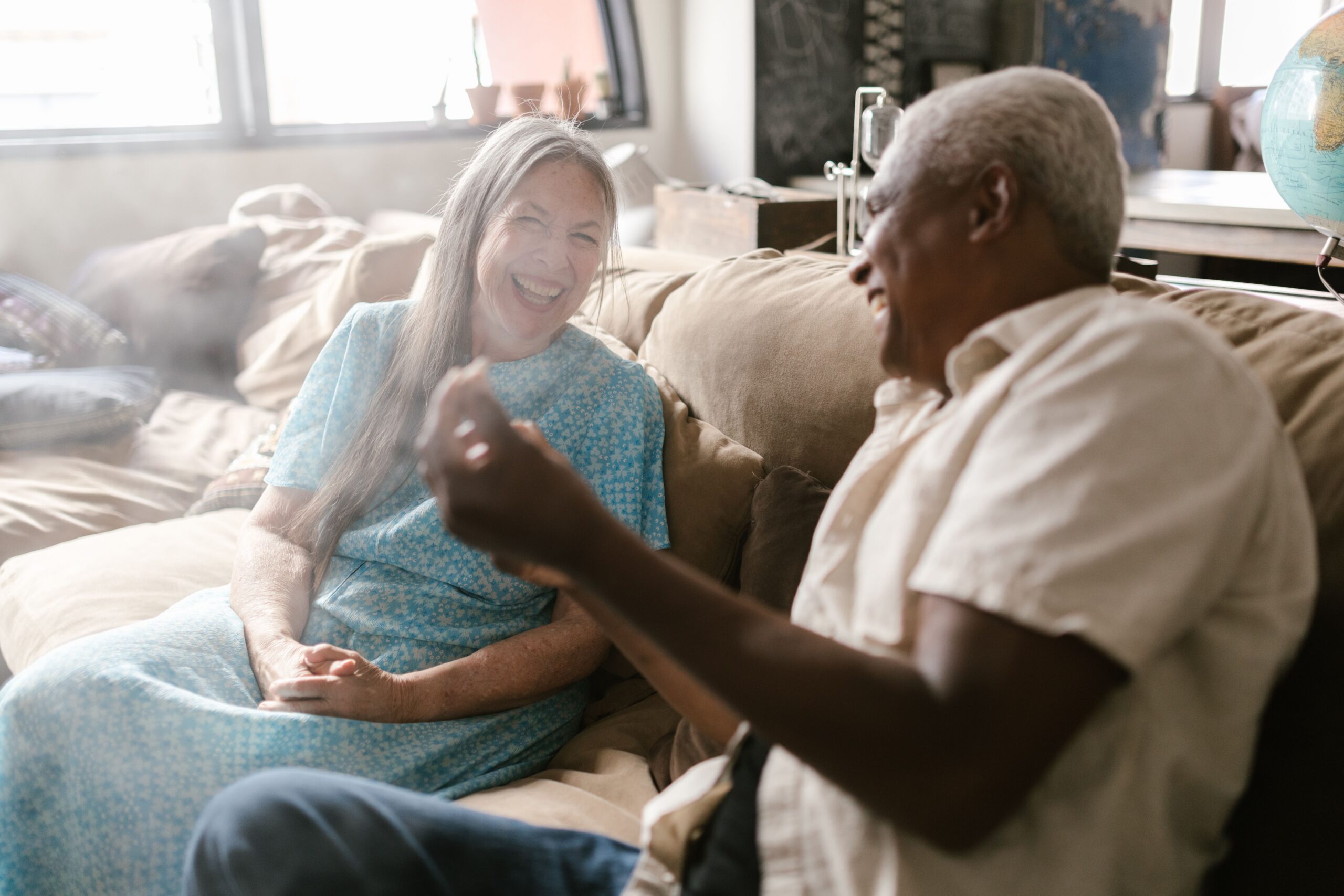 Older person laughing with their Elmes carer at home during a care review